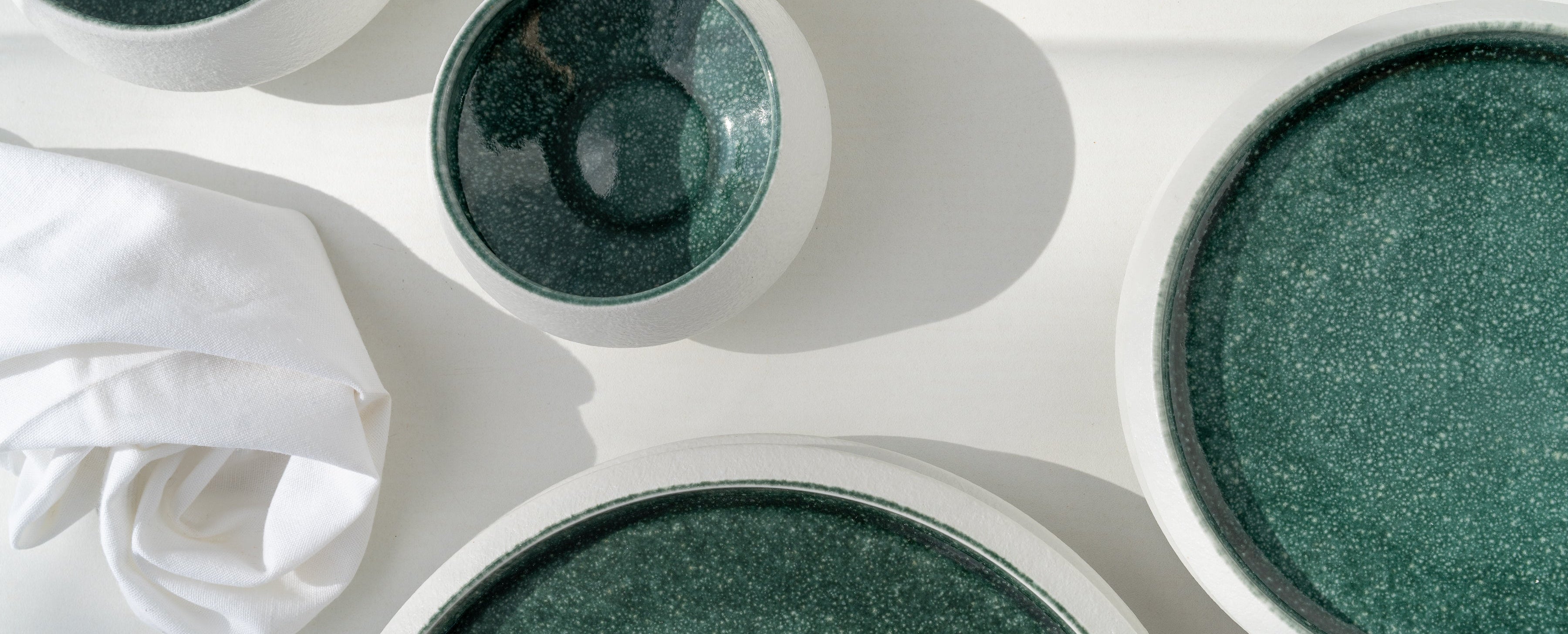 Green ceramic bowls on a white surface