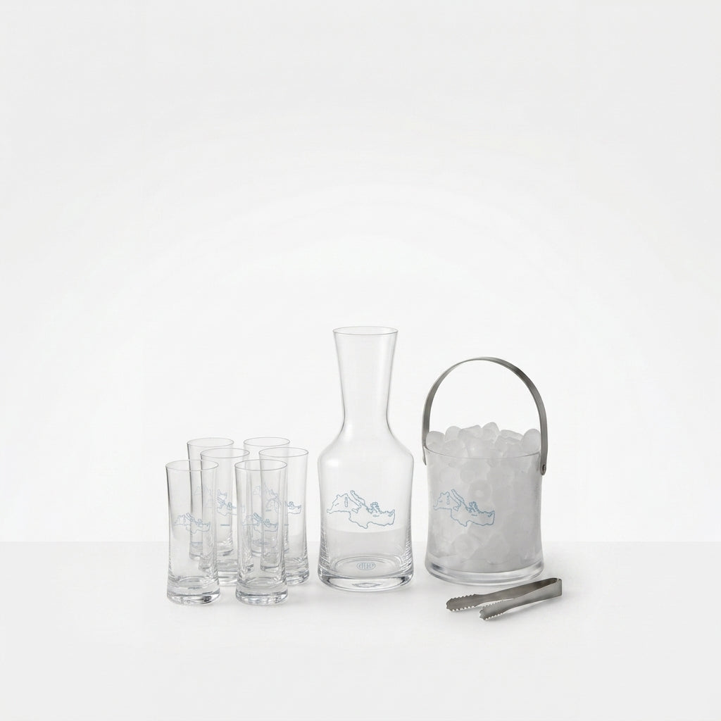 Clear glass carafe, ice bucket with ice, and glasses on a white background