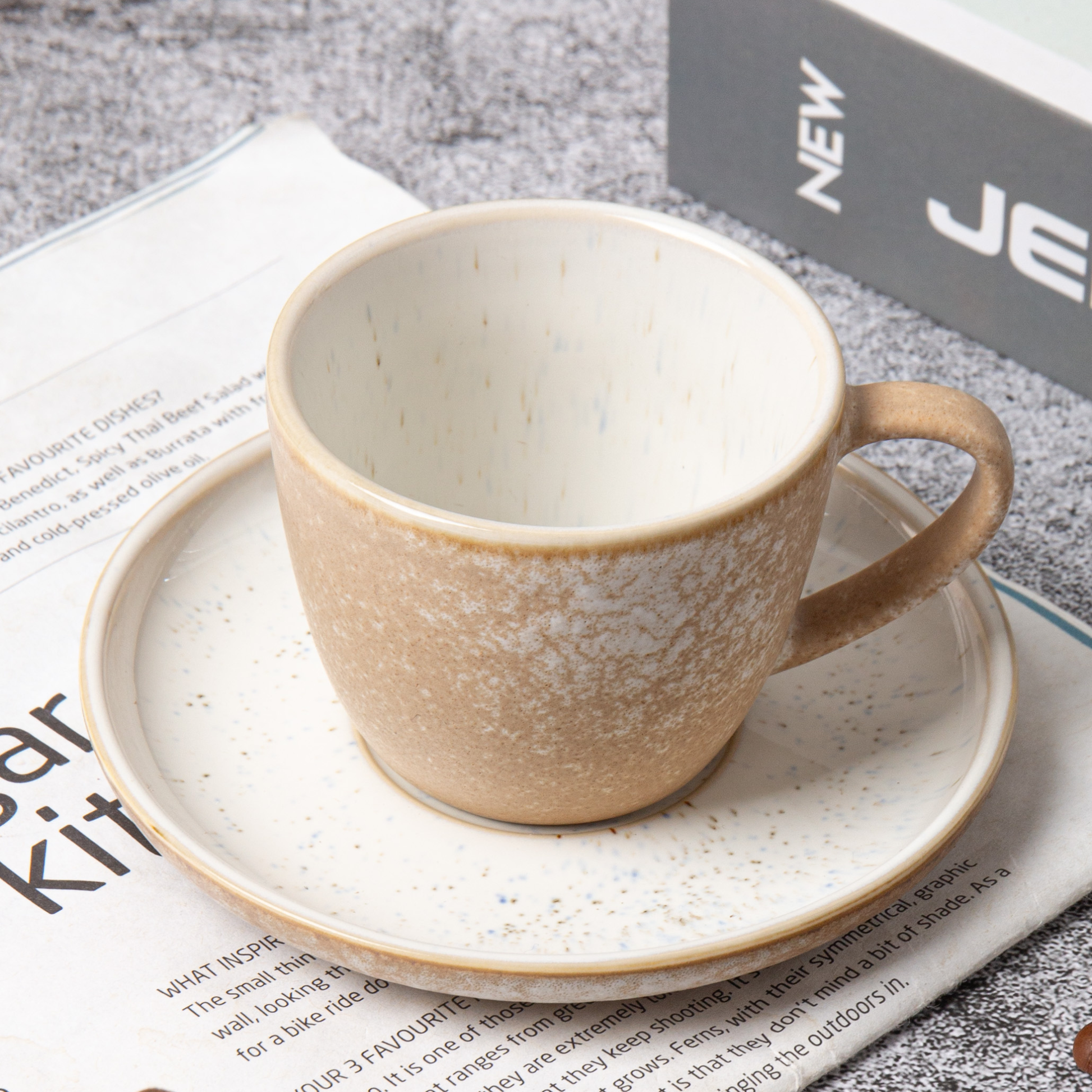 Ceramic cup and saucer on a newspaper background