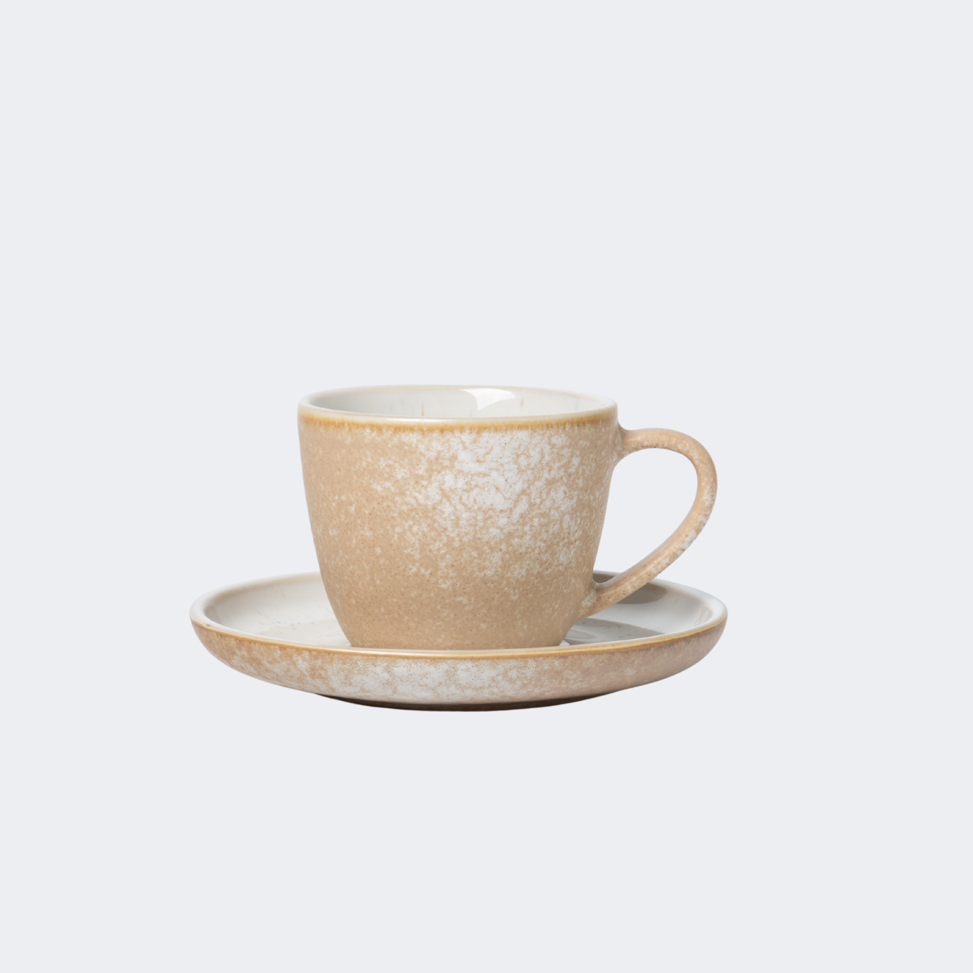 Beige ceramic cup and saucer on a light gray background