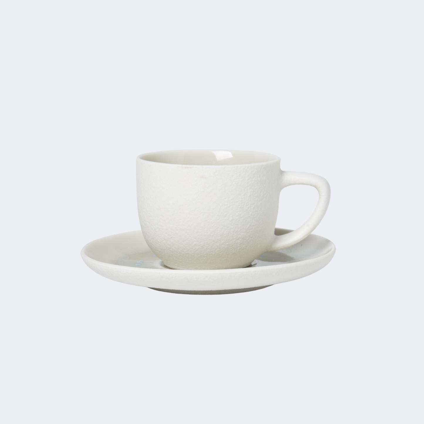 White ceramic cup and saucer on a light gray background