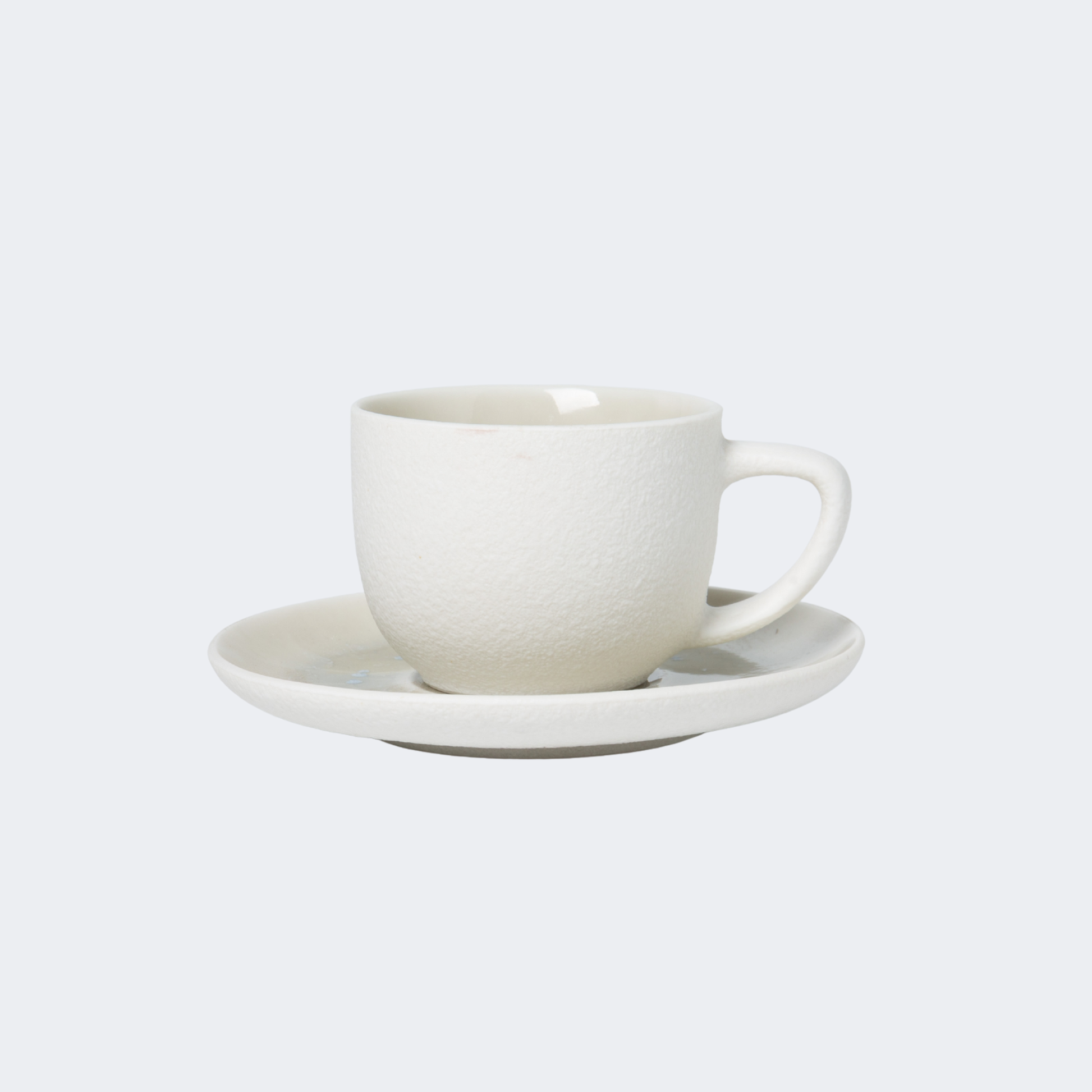 White ceramic cup and saucer on a light gray background