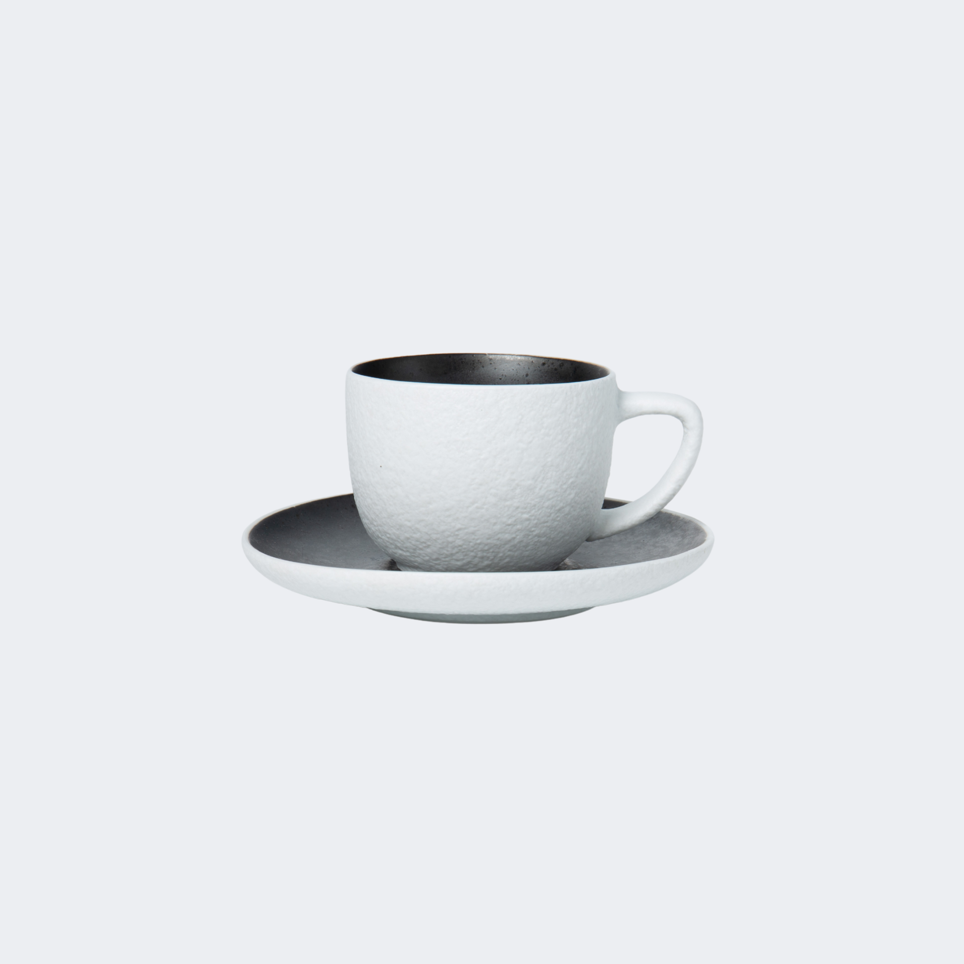 White ceramic cup and saucer set on a light gray background