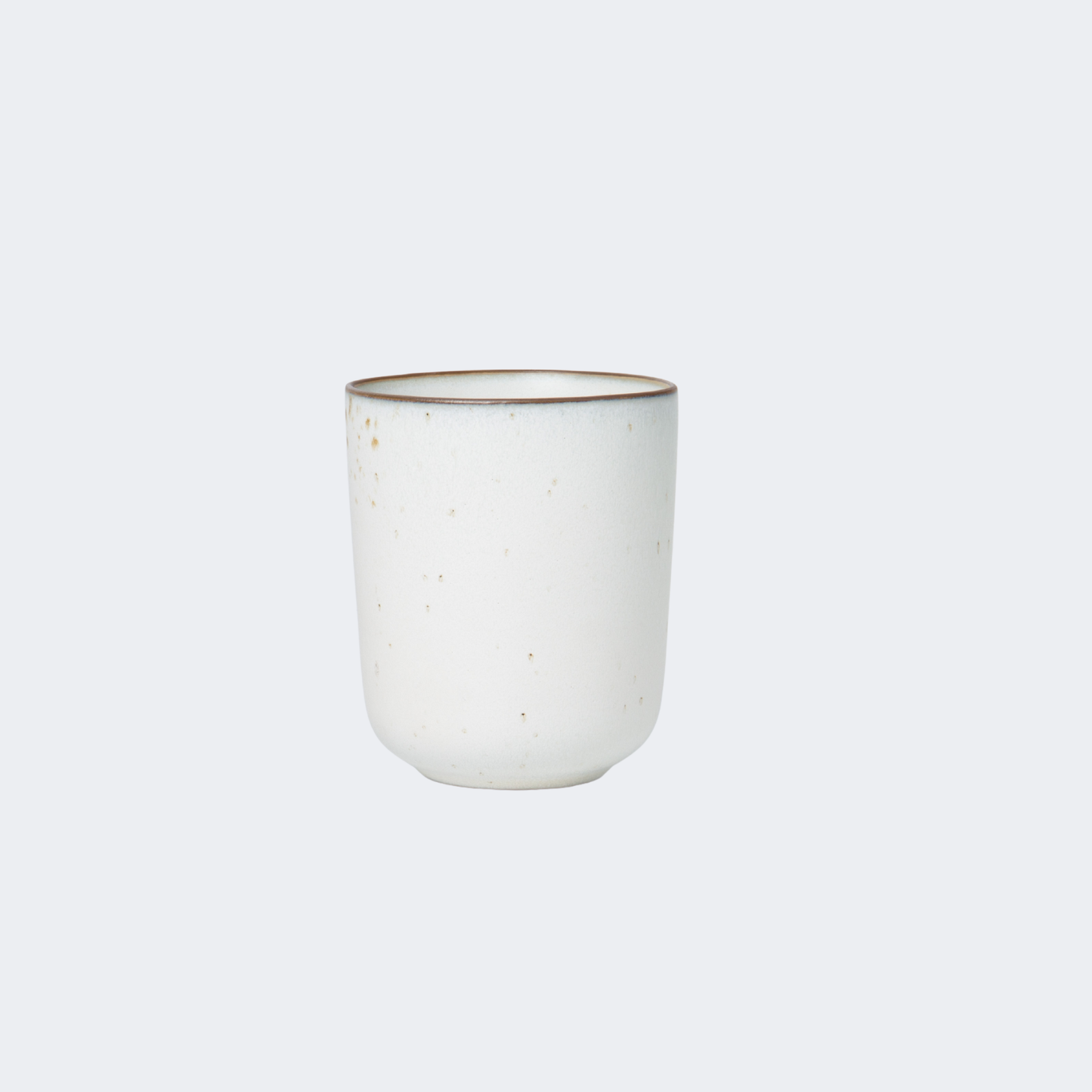 White ceramic cup with brown rim on a light gray background